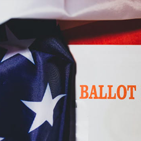 Red text “Ballot Enclosed” with portions of an American flag in the background.