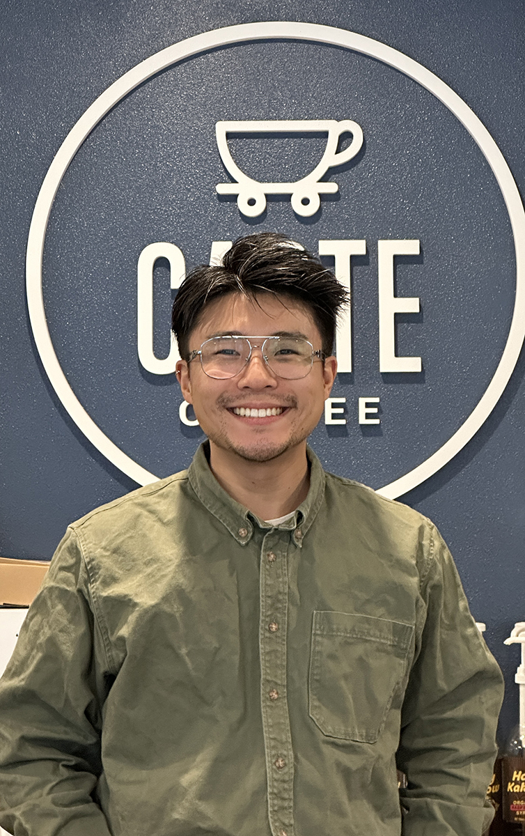 Portrait of Jushua Huh with short black hair, wearing glasses and a green shirt.