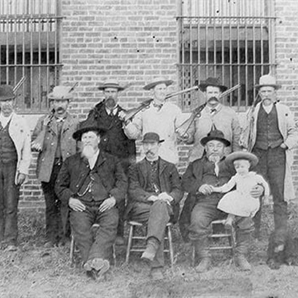 Vintage photograph of lawmen in front of a prison.