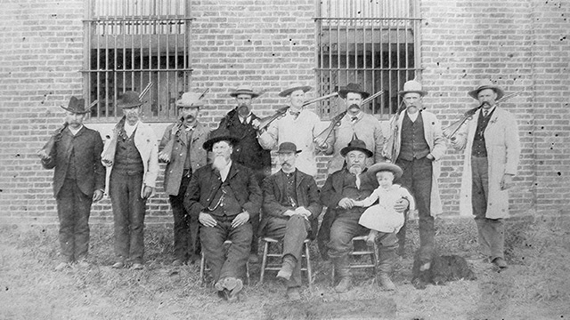 Vintage photograph of lawmen in front of a prison.