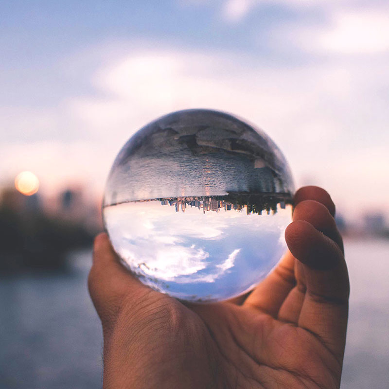 Looking at a city through a glass sphere held in a hand.