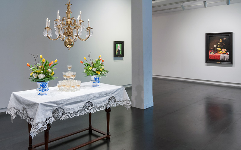 Art installation "View", table set up with a white table cloth and a pyramid of glasses and flower bouquets.