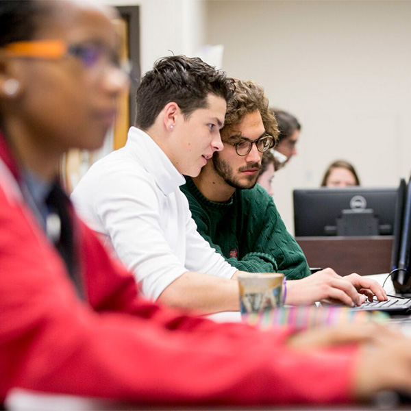 Image of a Whitman students helping each other on their Computer Science task.