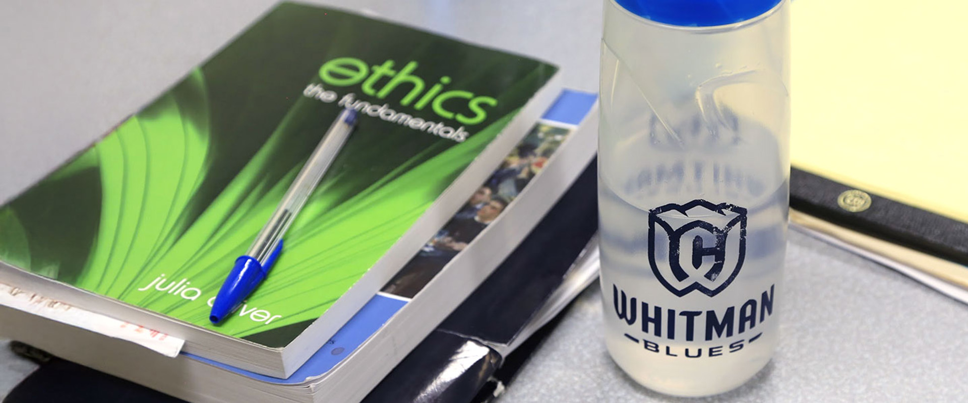 Ethics text book and Whitman College water bottle.