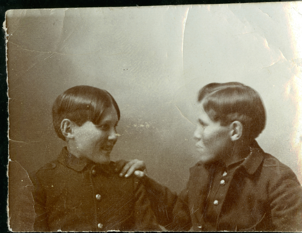 Old photograph of two brothers looking at each other.