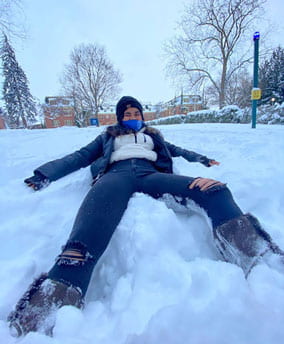 Bertine Lakjohn laying in the snow.