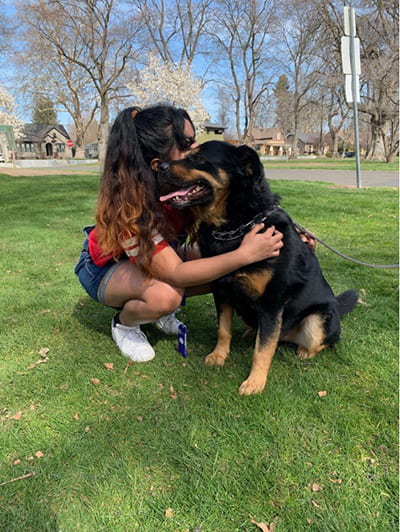 Bertine petting a dog on a sunny day.