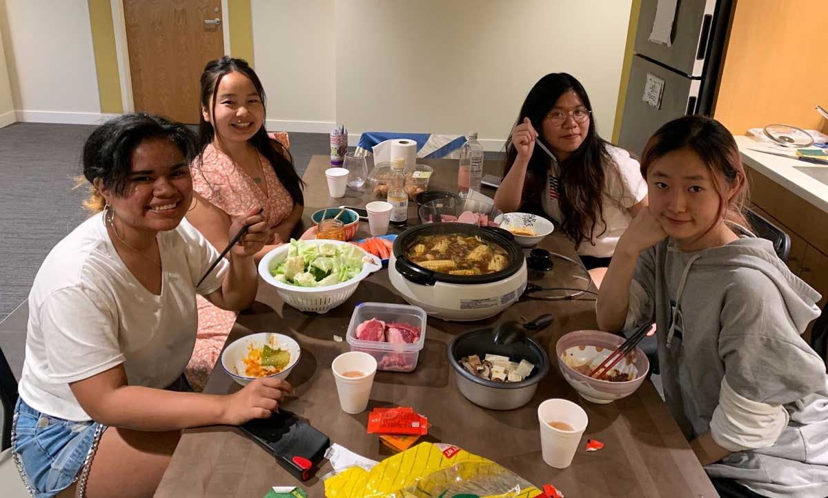 Bertine Lakjohn and friends sitting around the dinner table.