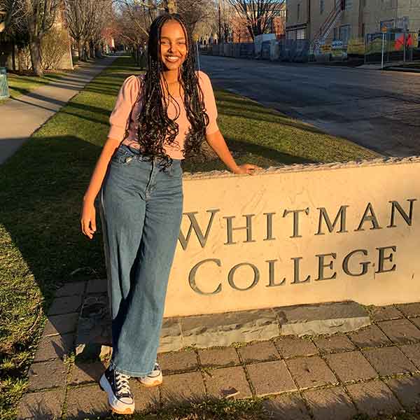 Ruth Chane standing next to a Whitman College sign.