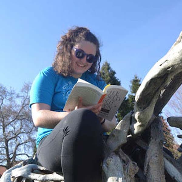 Zoe Perkins reading outdoors.