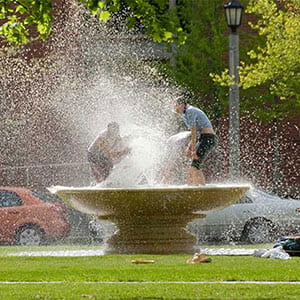 Students playing in a water fountain.