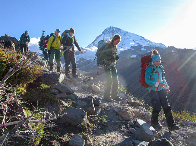 Whitman College students hiking on a mountain ridge.
