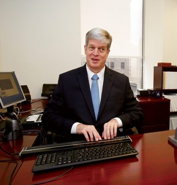 Kirk Adams seated at his desk