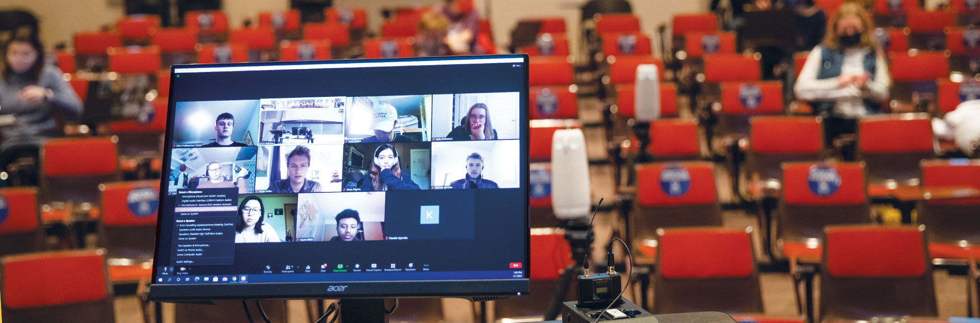 View of a computer screen with Zoom participants within an auditorium 