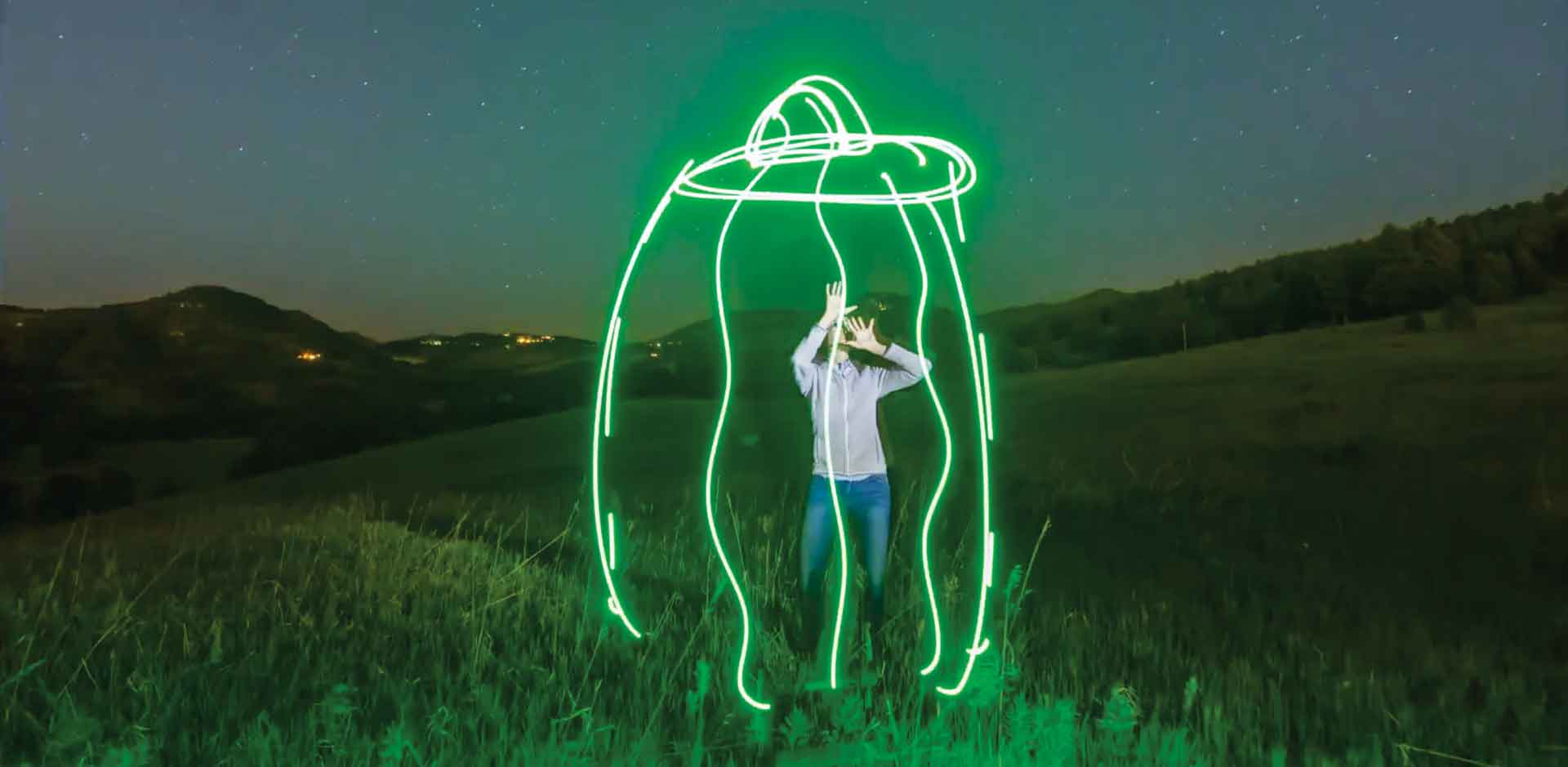 Laura Krantz in a field at night with a flying saucer effects added to the image