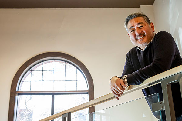 Eric Hayashi smiling from the balcony.