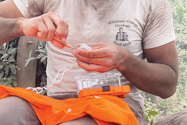 Hands fixing a rain gauge.