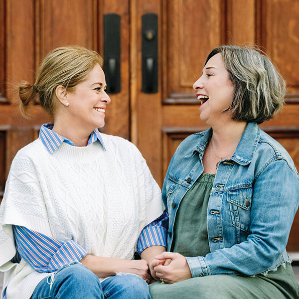 Julia Ireland and Joanie Lucarelli holding hands.