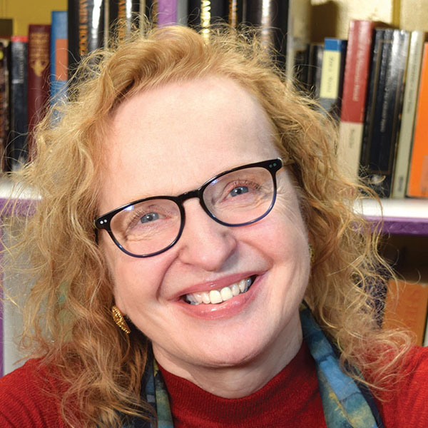 Sharon Alker in front of a bookcase.