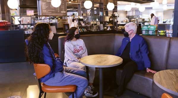 President Murray speaks with students inside Cleveland Commons.