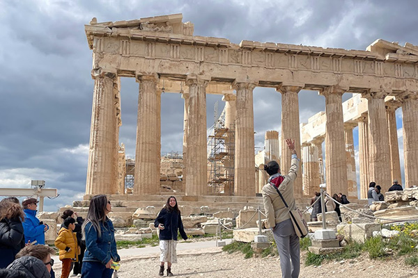 Student traveling in Greece in front of a greek ruin