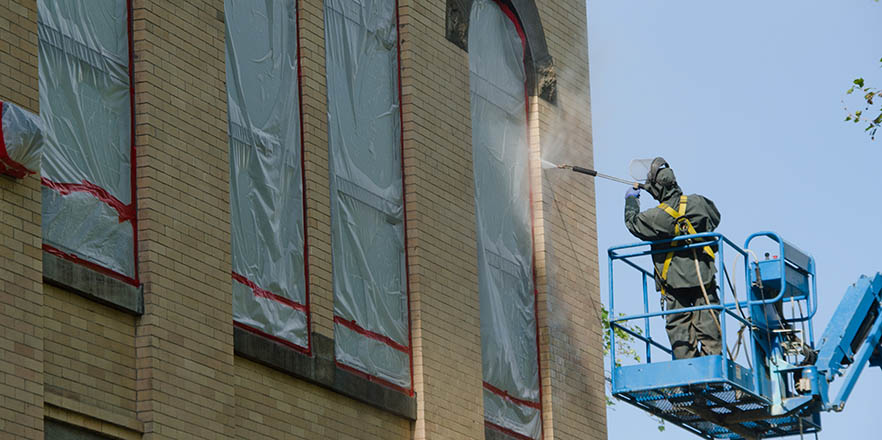 worker works on the outside of Memorial Bldg.