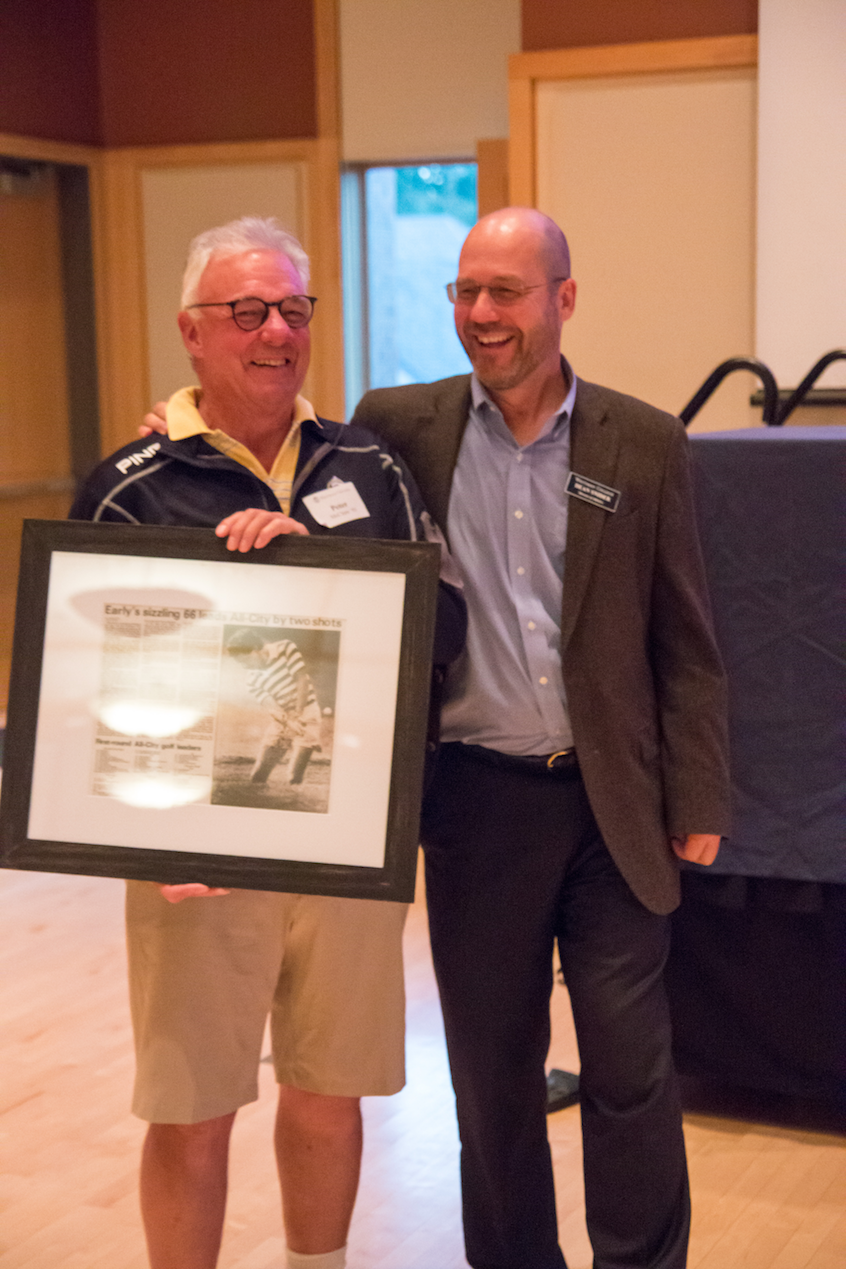 Men’s Golf Coach Peter McClure ’93 accepts a framed article from the "Union-Bulletin" from Athletics Director Dean Snider. McClure has announced his retirement following this season, his 25th.