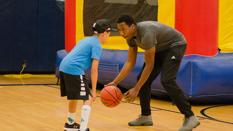 A Whitman student plays basketball with an elementary school student.