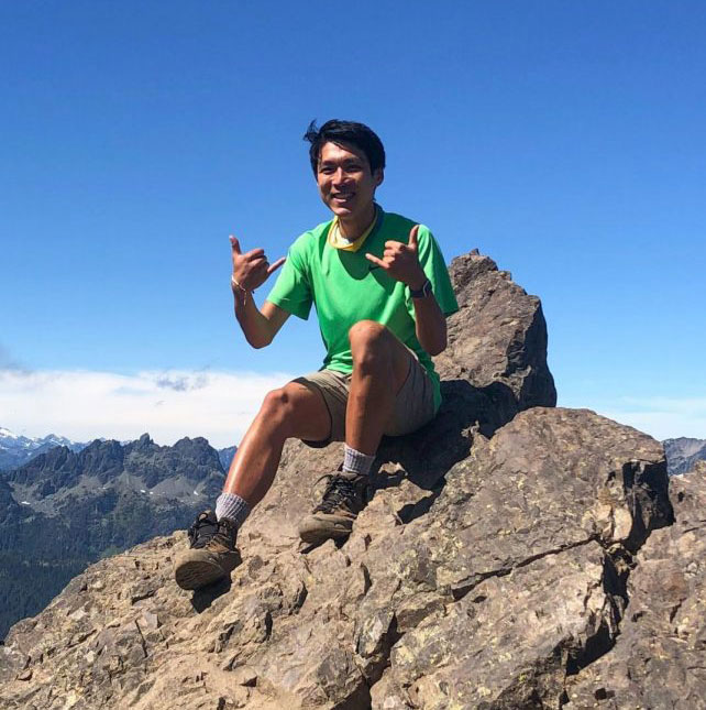 Jake Wang smiles atop a mountain