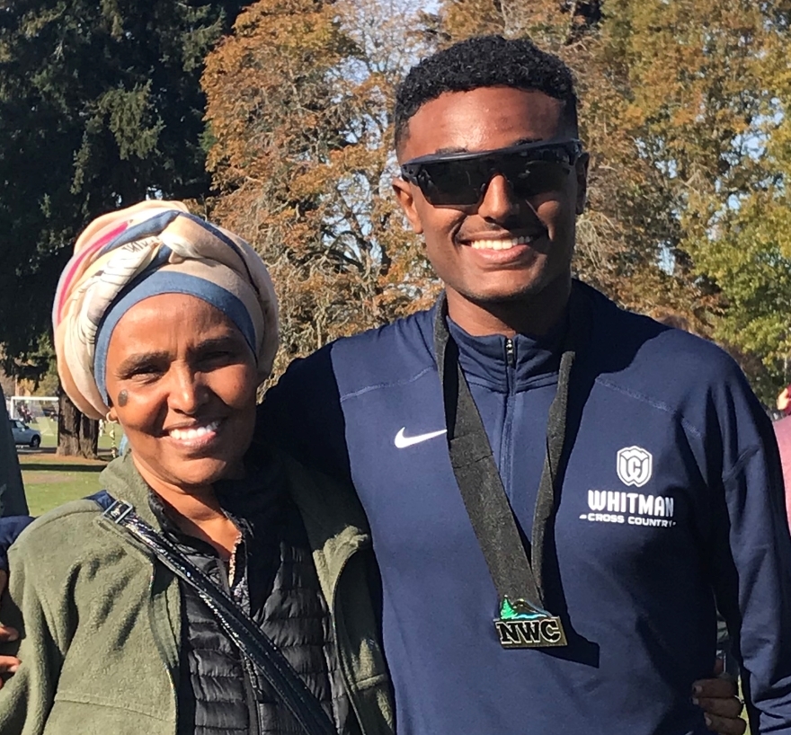 Saleh and his mom smile for a photo at the cross country team's conference race held in Walla Walla.