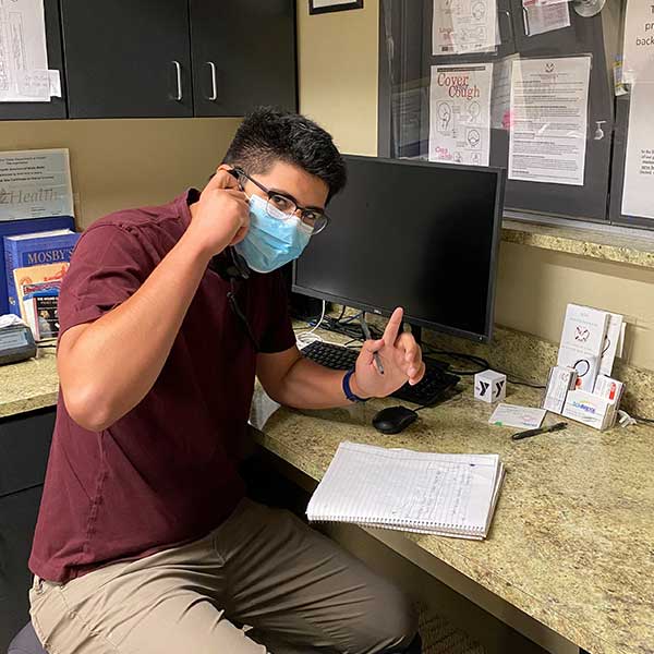 Erik Muro '23 translating over the phone for a patient at the SOS Health Services Clinic