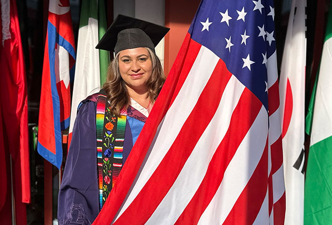 Salma Anguiano '22 poses with the United States flag while in her graduation regalia in Beijing, China.