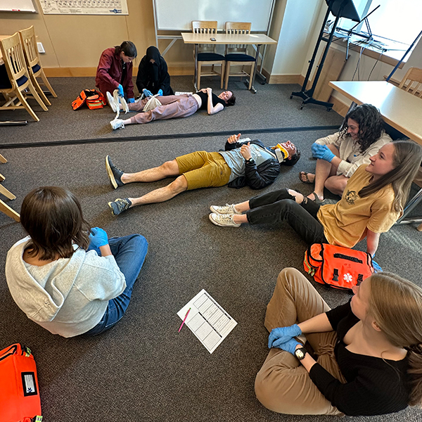 Student practice their medical training in a classroom environment.