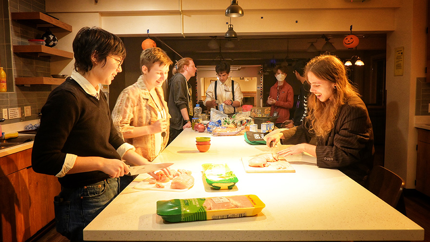 Students preparing food around a kitchen island