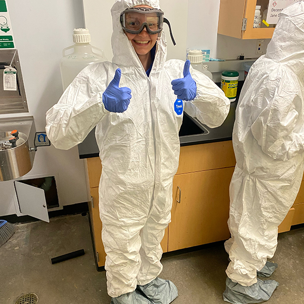 Anna Shimkus wears white protective gear in a lab setting.
