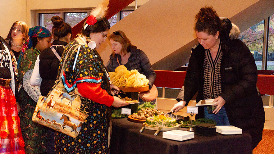 People in the buffet line serving food offered at the First Foods Festival.