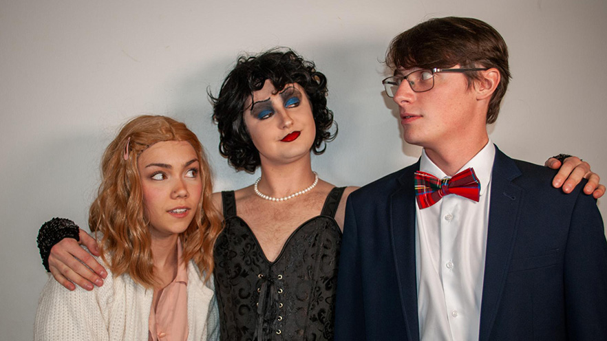 Three student cast members of the “Rocky Horror Picture Show” in their character costumes.