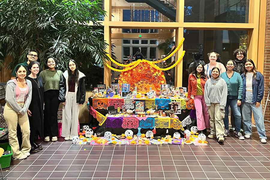 A colorful community ofrenda displaying photos and momentos of loved ones.