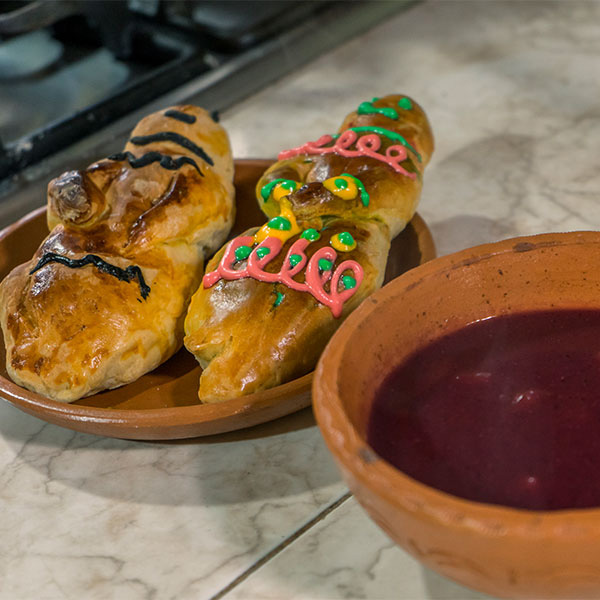 Two loves of sweet bread and a purple drink on a counter