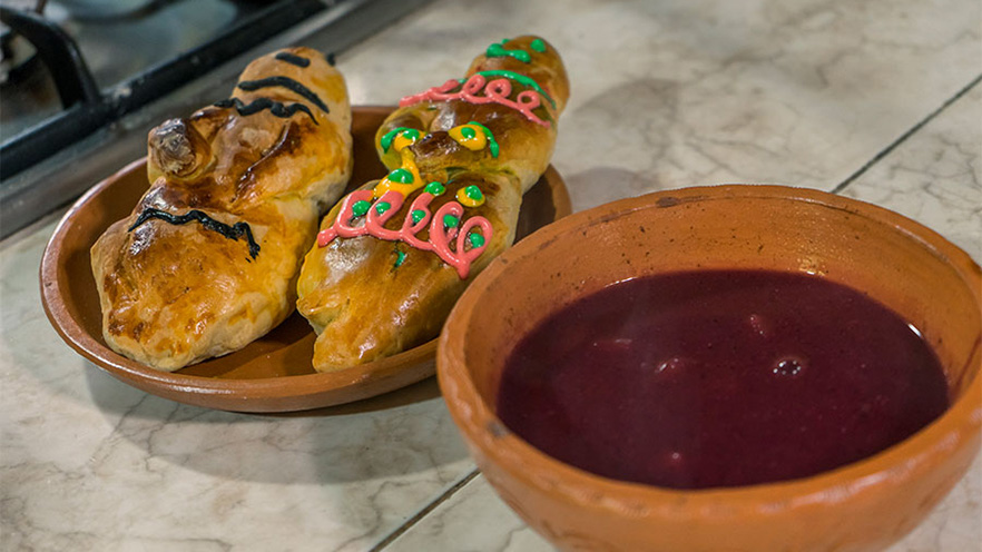 Two loaves of sweet bread and a purple drink on a counter