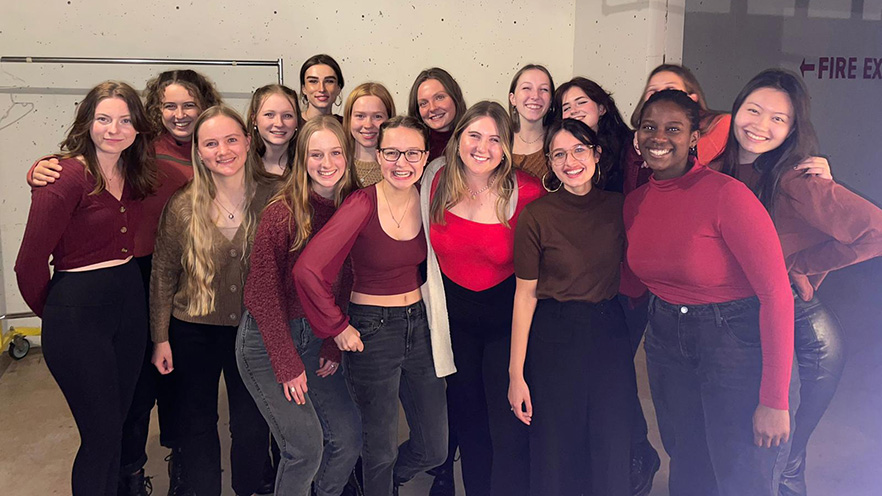 A soprano-alto a cappella group posing backstage