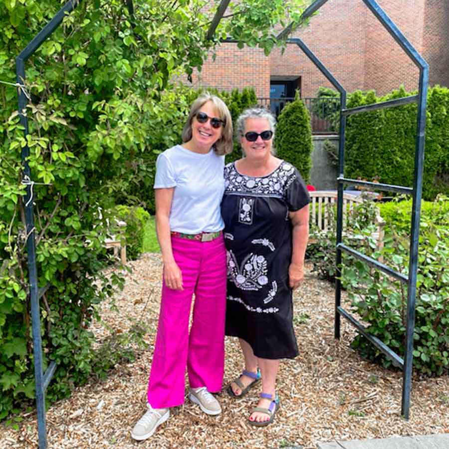 Molly McBranch '84 (left) and Chris Beard'84 (right) stand in a garden outside Maxey Hall at Whitman College.