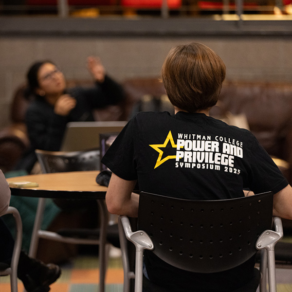 A black T-shirt with the text "Whitman College Power and Privilege Symposium 2025" 