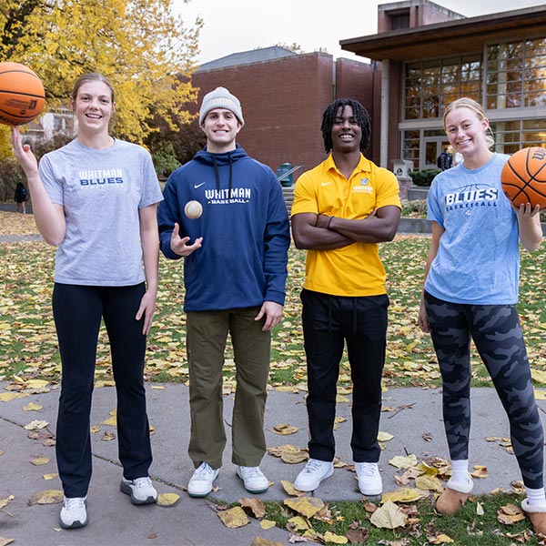 4 fifth year athletes standing outdoors.