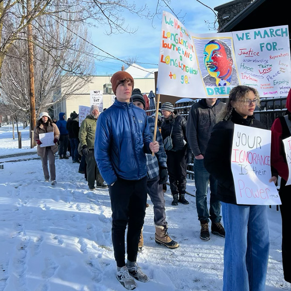 Students march down a snowy street holding signs