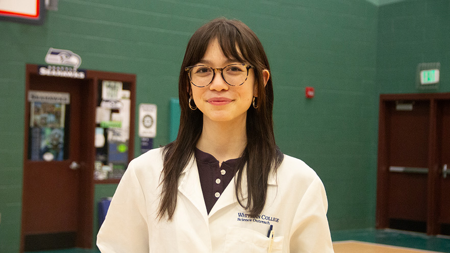 Whitman College Student posing for a picture with a lab coat on.