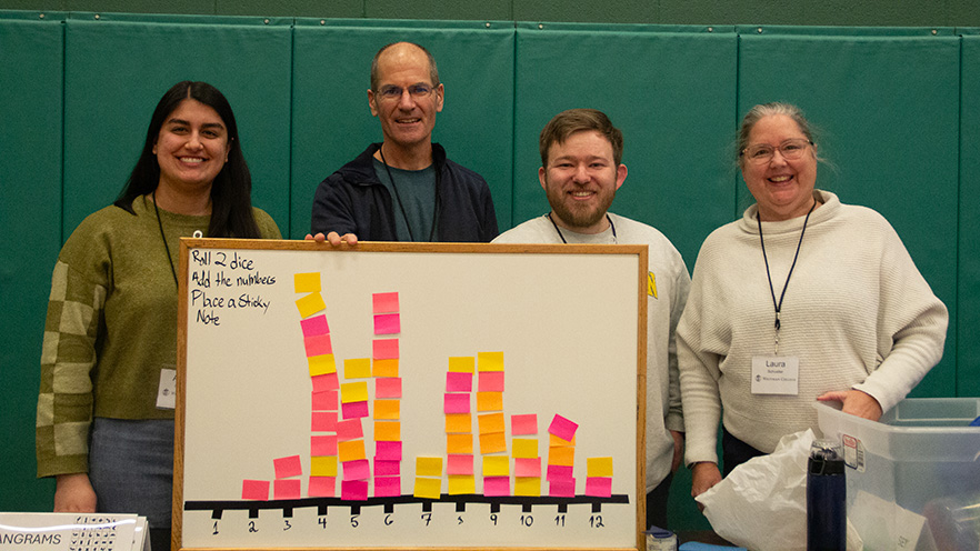 Whitman College faculty posing in front of a dice rolling experiment.