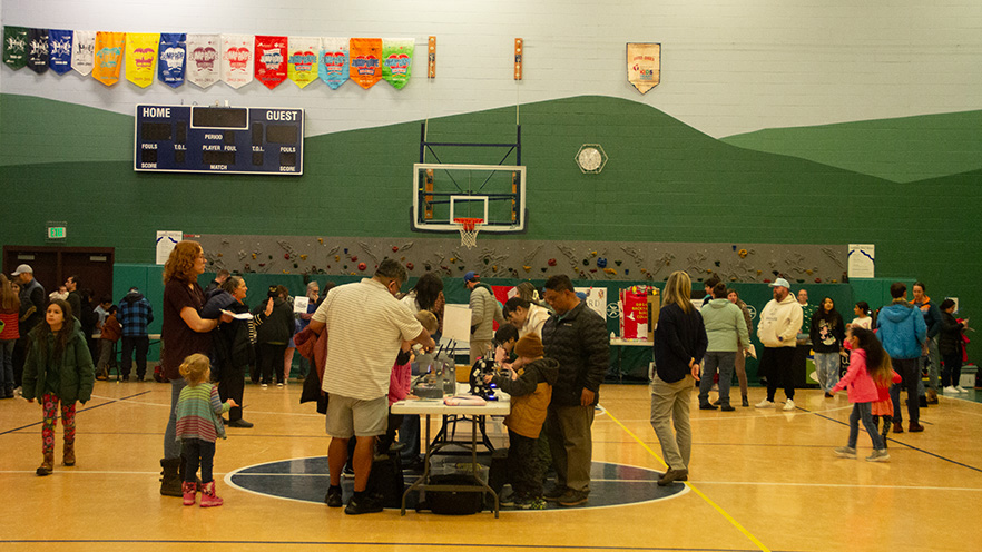 Families spread across the gym visiting various booths at the Whitman Science Night.