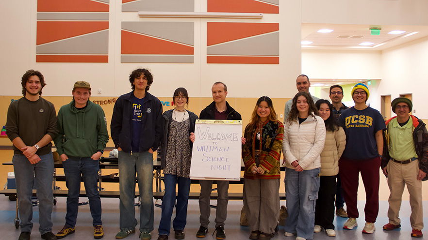 Whitman College students posing with a faculty member holding a sign saying "Welcome to Whitman Science Night"."