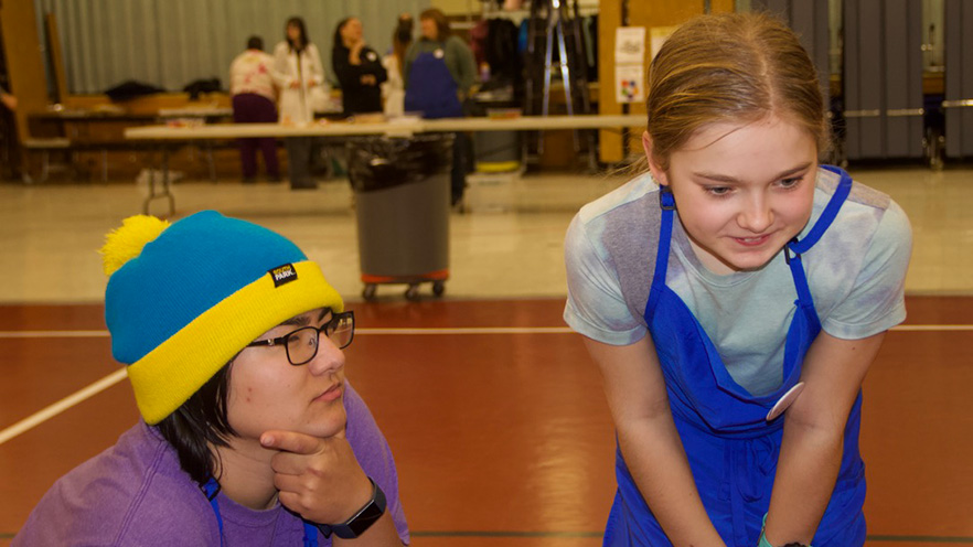 Whitman College student looking at something attentively with child that attended Whitman Science Night. 